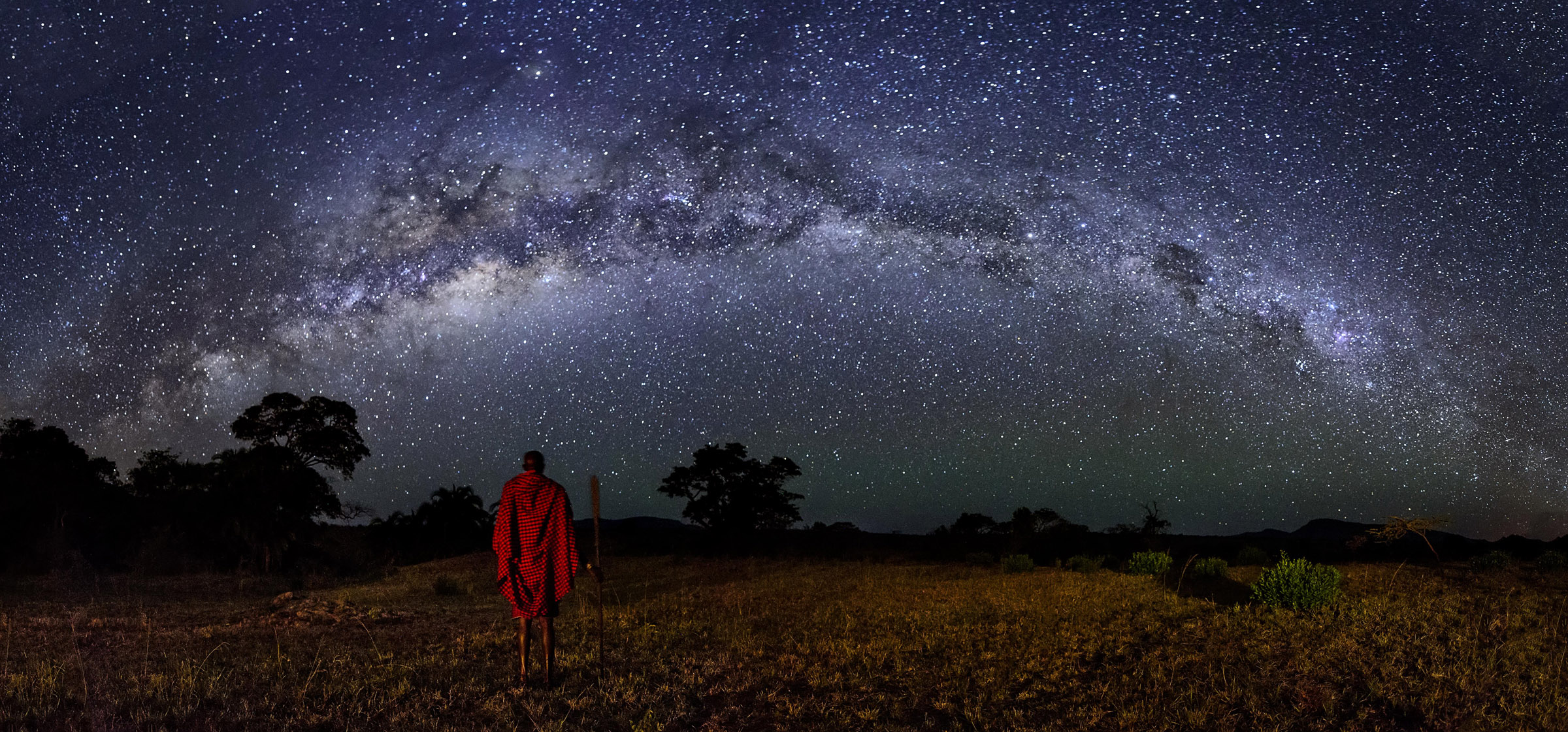 Maasai warrior under the African night sky in Kenya by Nando Morales